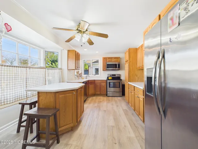 a kitchen with stainless steel appliances a table chairs refrigerator and cabinets