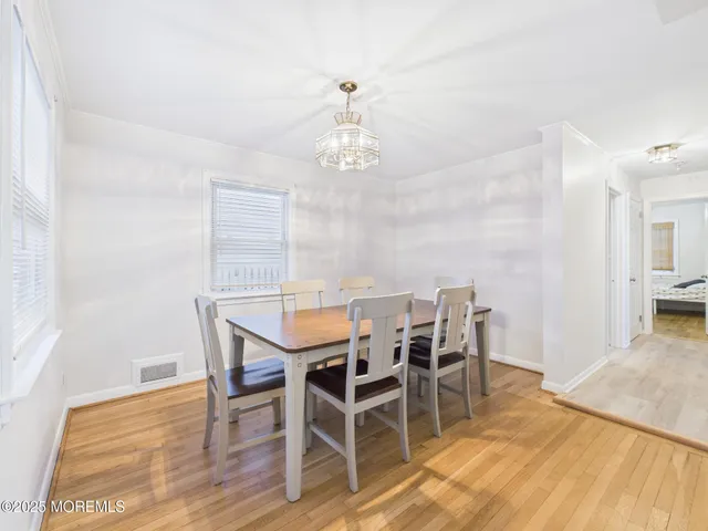 a view of a dining room with furniture wooden floor and chandelier