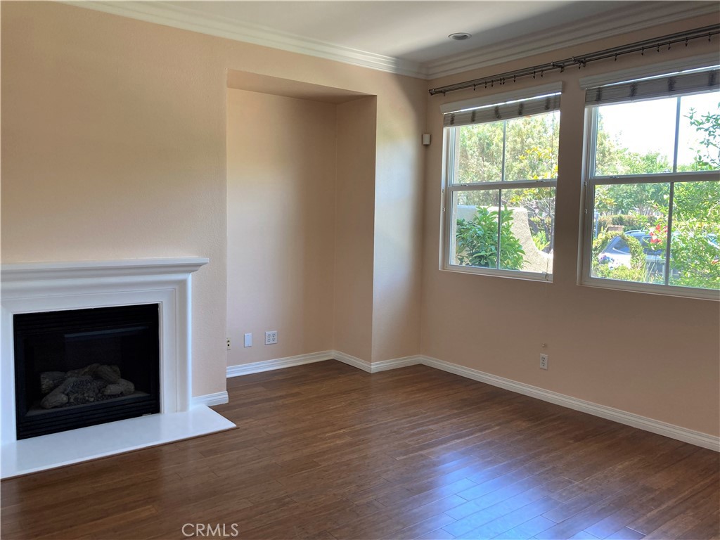 26 Opus Irvine, CA 92618 - Photo 10 of 32 an empty room with wooden floor fireplace and windows