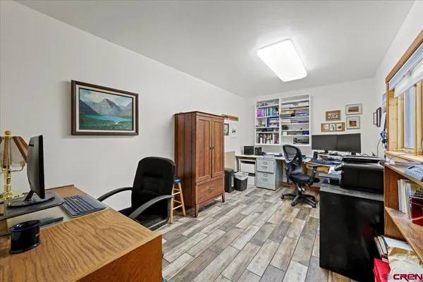 a view of a workspace with furniture and a window