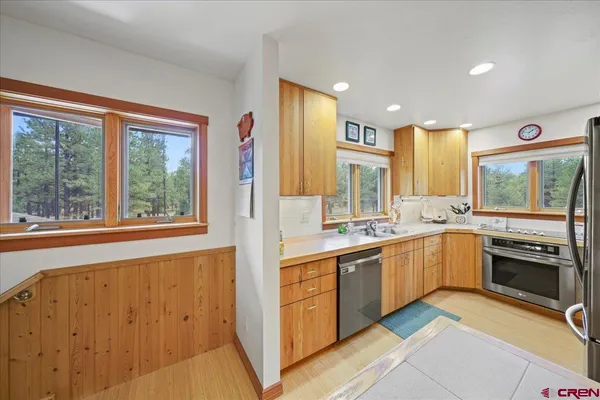 a large kitchen with stainless steel appliances granite countertop a stove and a sink