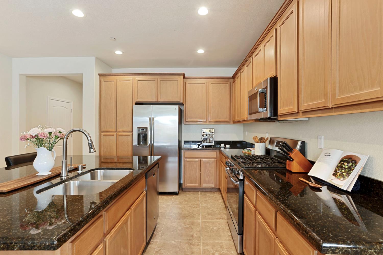 a kitchen with stainless steel appliances granite countertop a sink stove and refrigerator