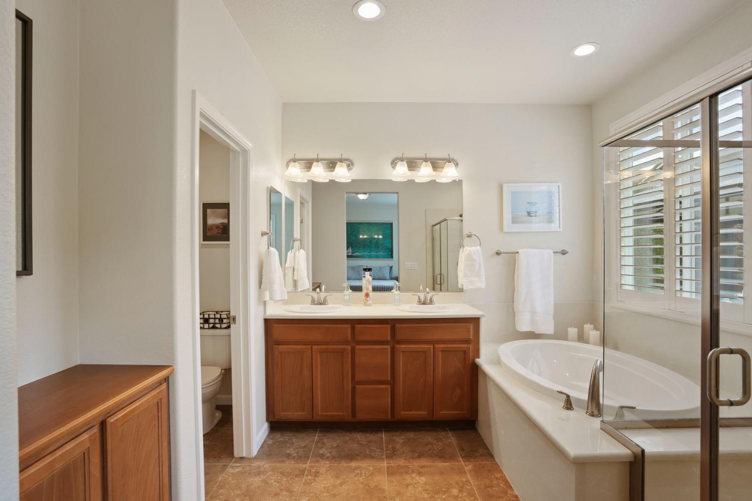 3828 Lookout Drive Modesto, CA 95355 - Photo 20 of 39 a bathroom with a tub a sink and mirror