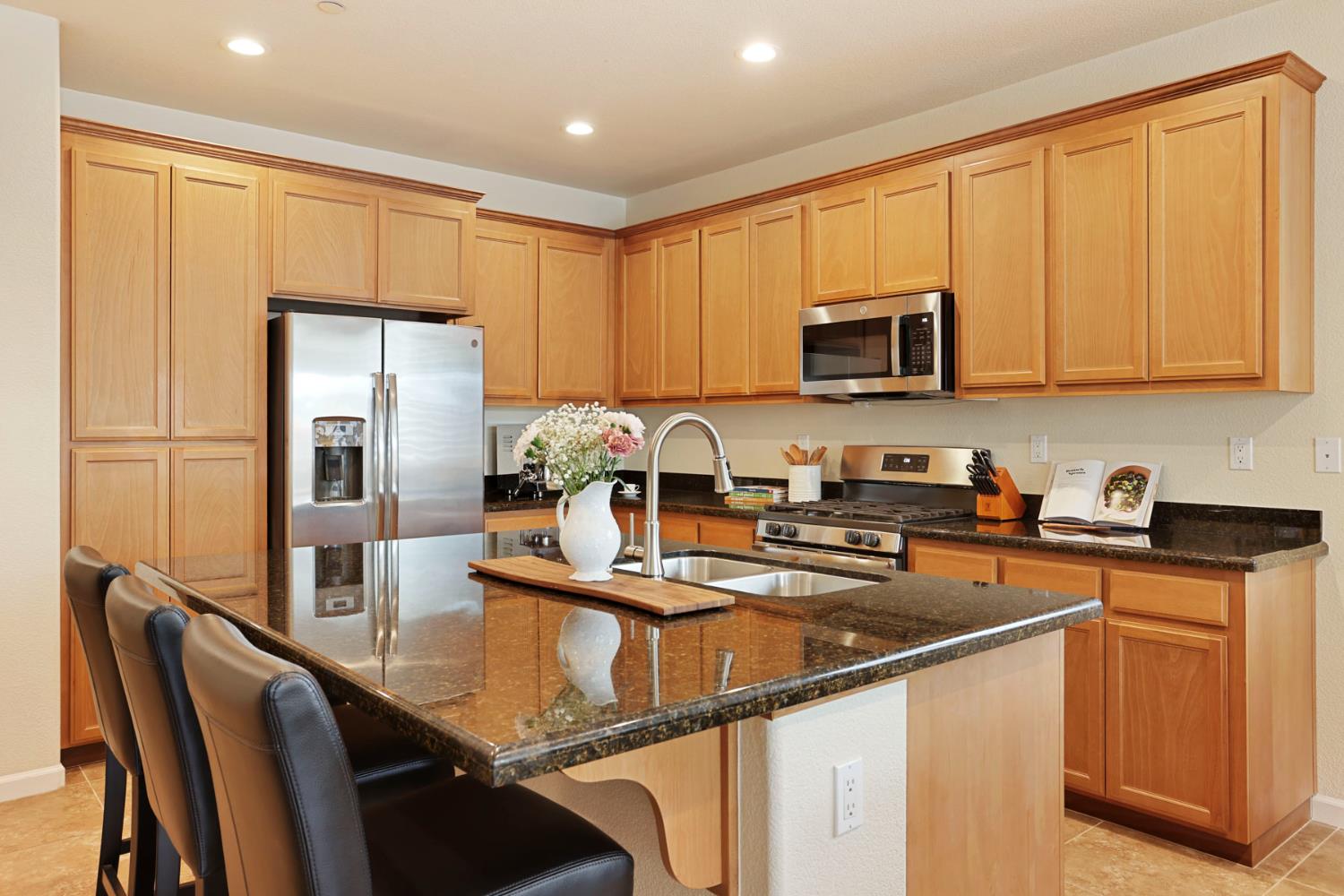 3828 Lookout Drive Modesto, CA 95355 - Photo 8 of 39 a kitchen with kitchen island granite countertop a stove top oven a sink a counter space and refrigerator