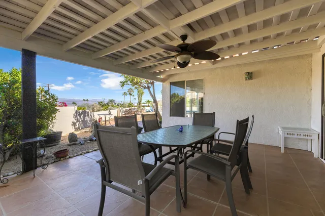 an empty room with window and ceiling fan