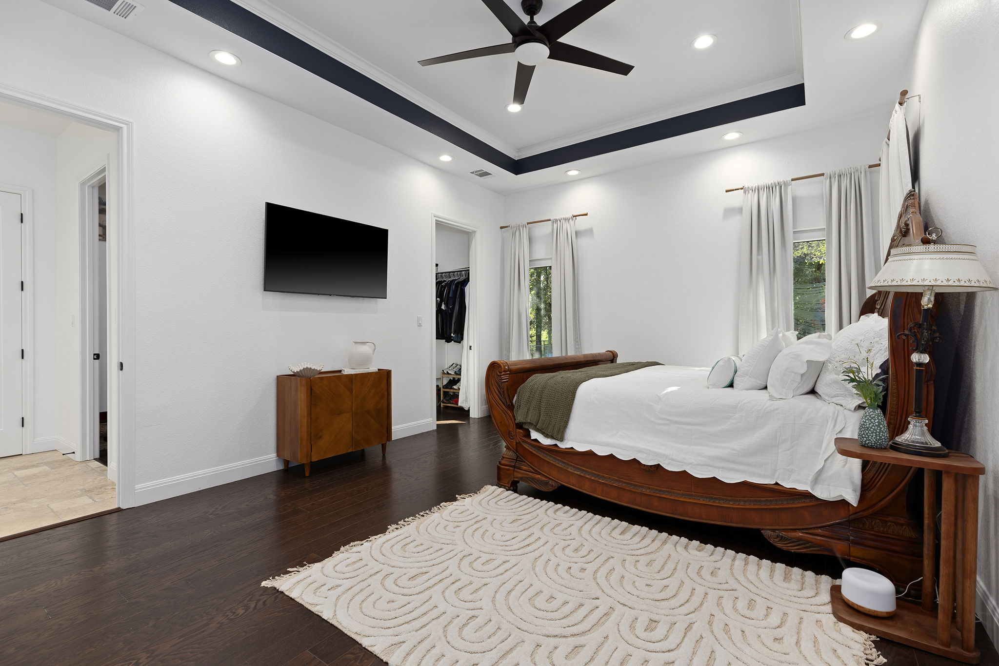 153 Fawn Hollow Elgin, TX 78621 - Photo 20 of 40 a bedroom with a bed a flat screen tv and a chandelier