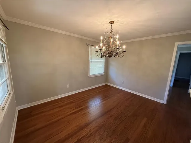a view of a room with wooden floor and chandelier