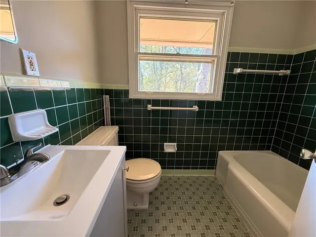a bathroom with a sink a toilet a bathtub and a window