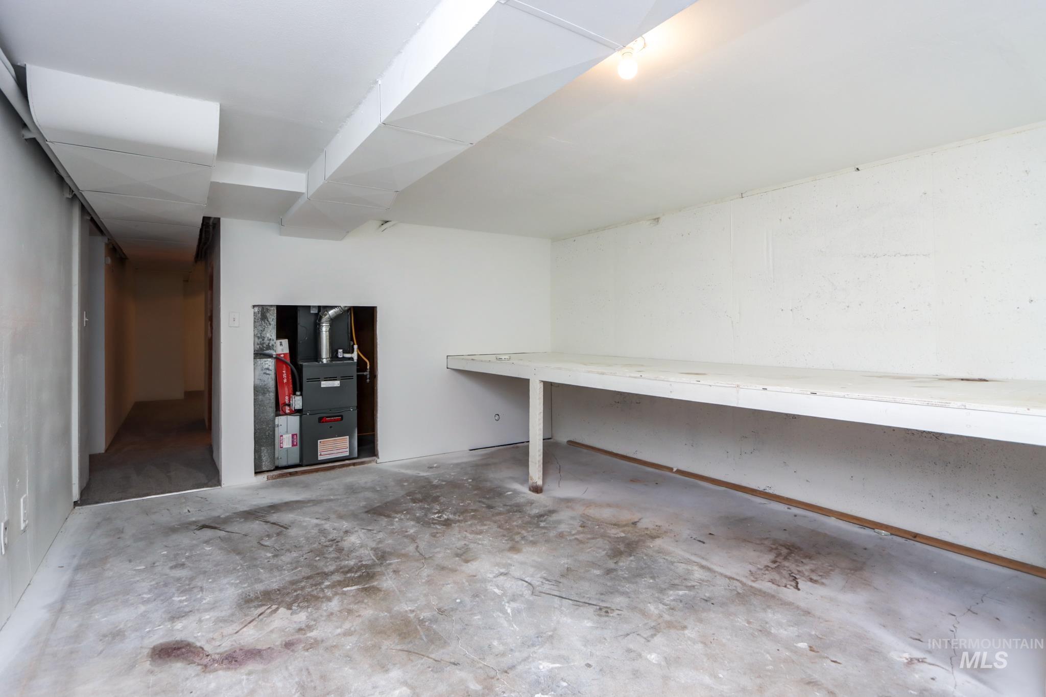 801 Thompson Avenue Nyssa, OR 97913 - Photo 35 of 46 Unfinished utility room featuring an exposed furnace, concrete flooring, and an integrated workbench