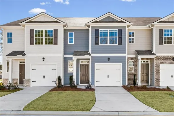 a view of a brick house with many windows and a yard