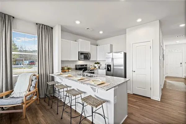 a kitchen with a refrigerator a stove a dining table and chairs