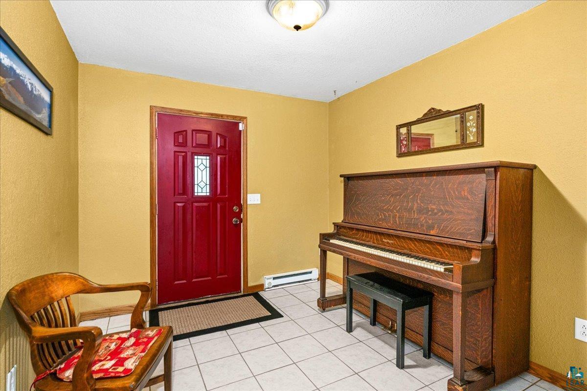 5195 Lavaque Junction Road Hermantown, MN 55811 - Photo 7 of 66 Entryway featuring a red paneled door with decorative glass inserts, wood-finish trim, and light-toned square floor tiles
