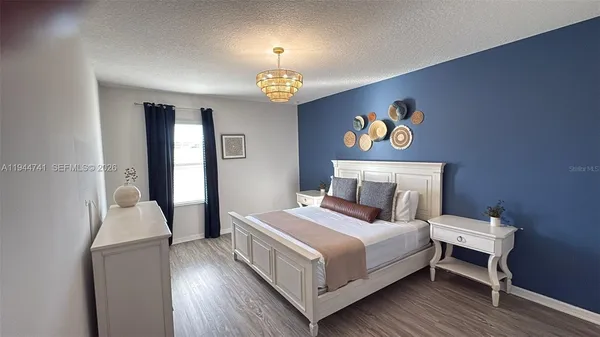 a bedroom with a bed and a chandelier