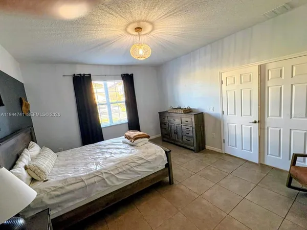 a bedroom with a bed and a chandelier