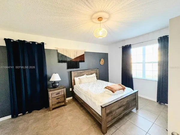 a bed sitting in a bedroom and chandelier