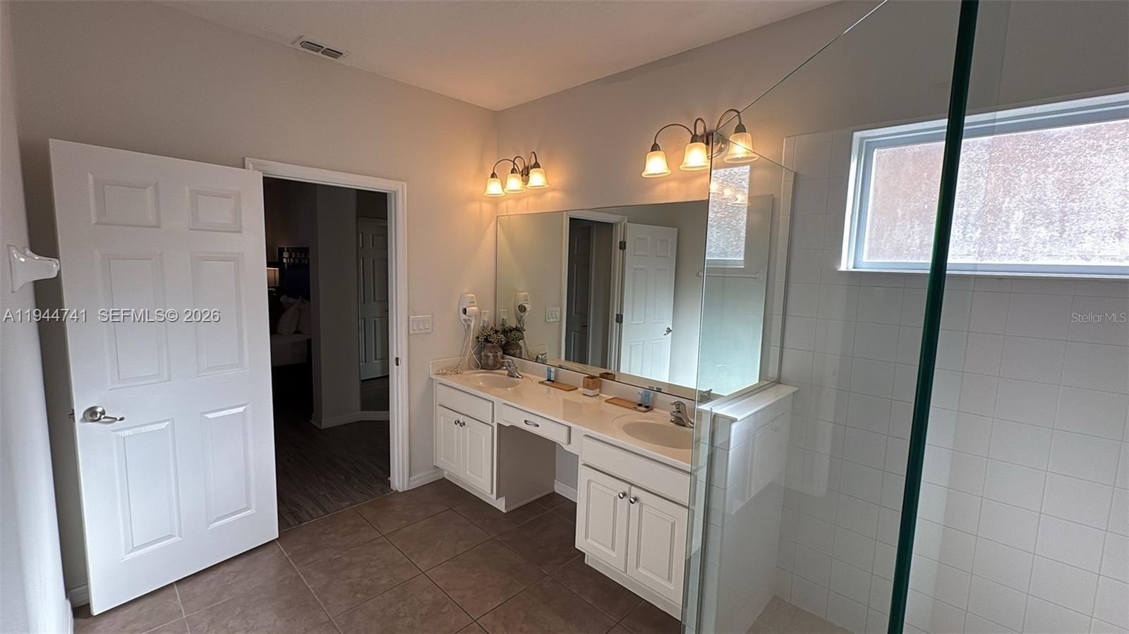 4445 Shiva Loop, Unit 4445 Kissimmee, FL 34746 - Photo 25 of 31 a bathroom with a double vanity sink and a mirror