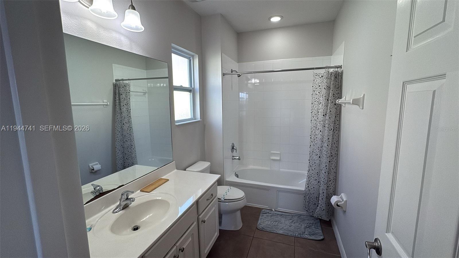 4445 Shiva Loop, Unit 4445 Kissimmee, FL 34746 - Photo 27 of 31 a bathroom with a granite countertop sink toilet and shower