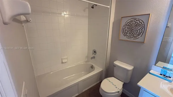 a white toilet sitting next to a bath tub