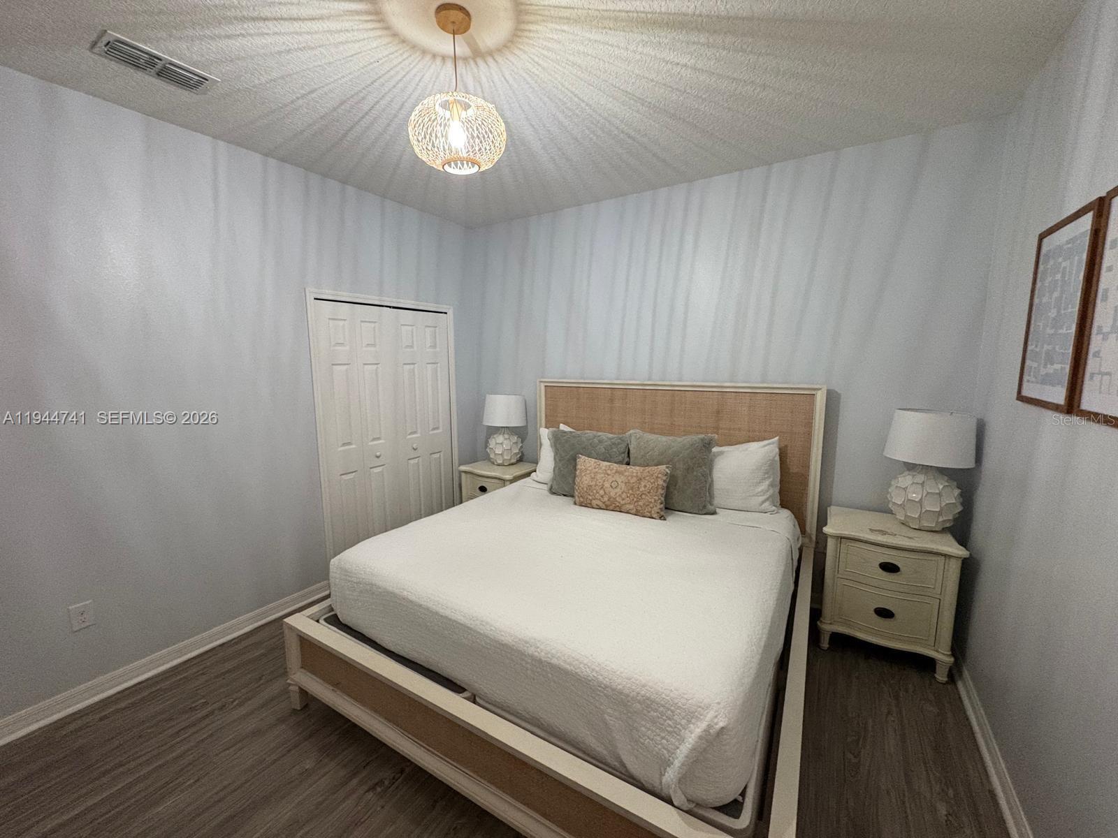 4445 Shiva Loop, Unit 4445 Kissimmee, FL 34746 - Photo 10 of 31 a bedroom with a bed and a chandelier