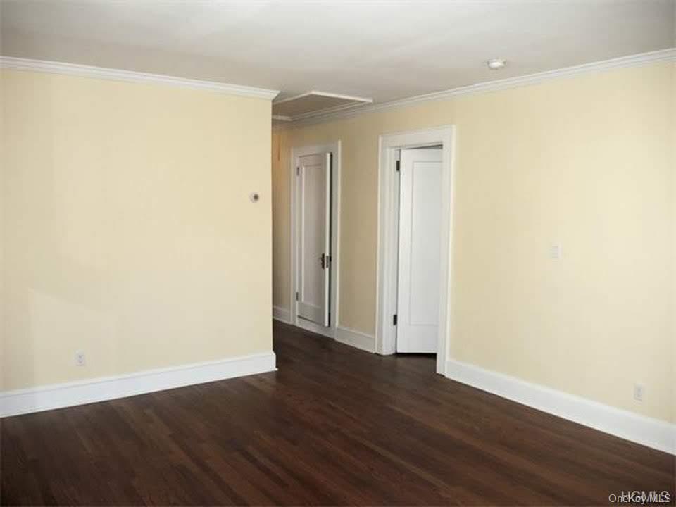471 Webster Avenue New Rochelle, NY 10801 - Photo 15 of 22 Spare room featuring dark wood finished floors and crown molding