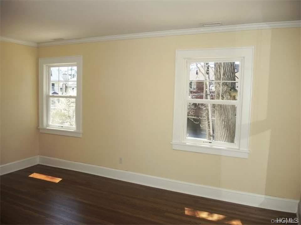 471 Webster Avenue New Rochelle, NY 10801 - Photo 16 of 22 Unfurnished room featuring crown molding and dark wood-type flooring