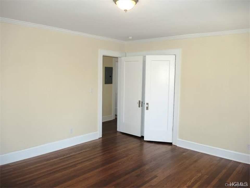 471 Webster Avenue New Rochelle, NY 10801 - Photo 17 of 22 Spare room with dark wood finished floors, ornamental molding, and electric panel