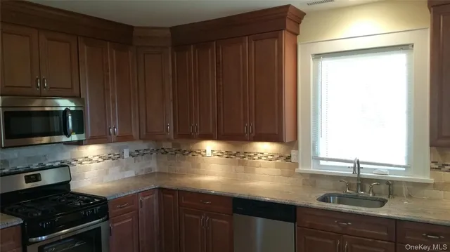 a kitchen with granite countertop wooden cabinets and a stove top oven
