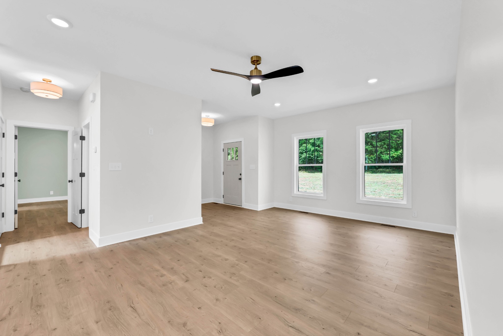 5590 Chambers Road Cumberland Furnace, TN 37051 - Photo 8 of 47 an empty room with wooden floor a ceiling fan and windows
