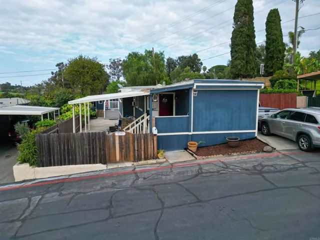 a backyard of a house with table and chairs a barbeque