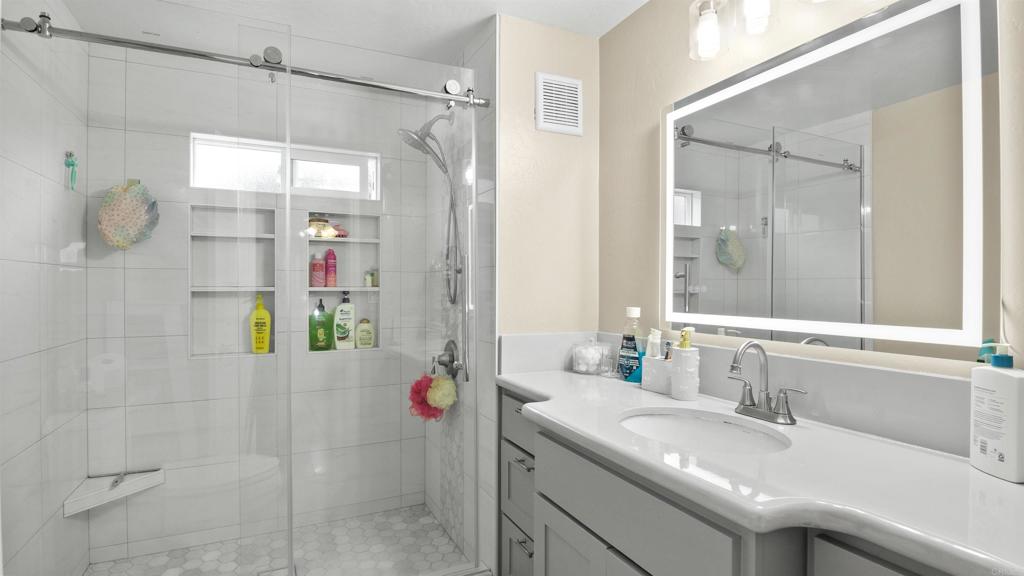 1455 Alturas Street, Unit 46 Fallbrook, CA 92028 - Photo 18 of 34 a bathroom with a granite countertop sink a shower and a mirror