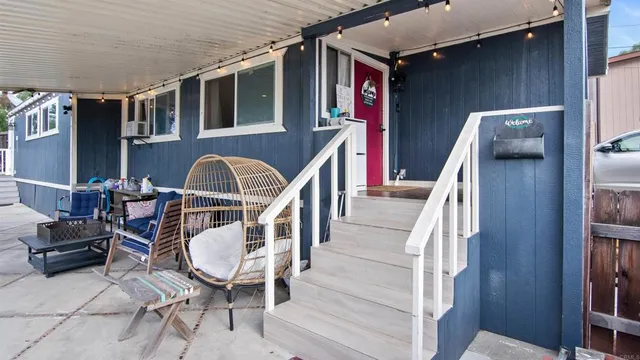 a front view of a house with outdoor seating and barbeque grill