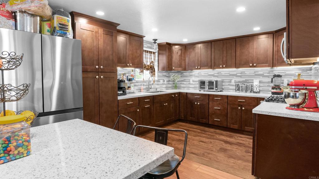 1455 Alturas Street, Unit 46 Fallbrook, CA 92028 - Photo 5 of 34 a kitchen with stainless steel appliances kitchen island granite countertop a sink refrigerator and cabinets