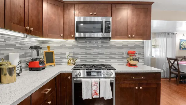 a kitchen with stainless steel appliances wooden cabinets and a stove top oven