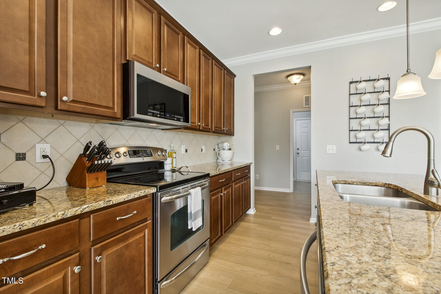 3604 Norman Blalock Road Willow Spring, NC 27592 - Photo 24 of 51 a kitchen with stainless steel appliances granite countertop a stove a sink and a microwave