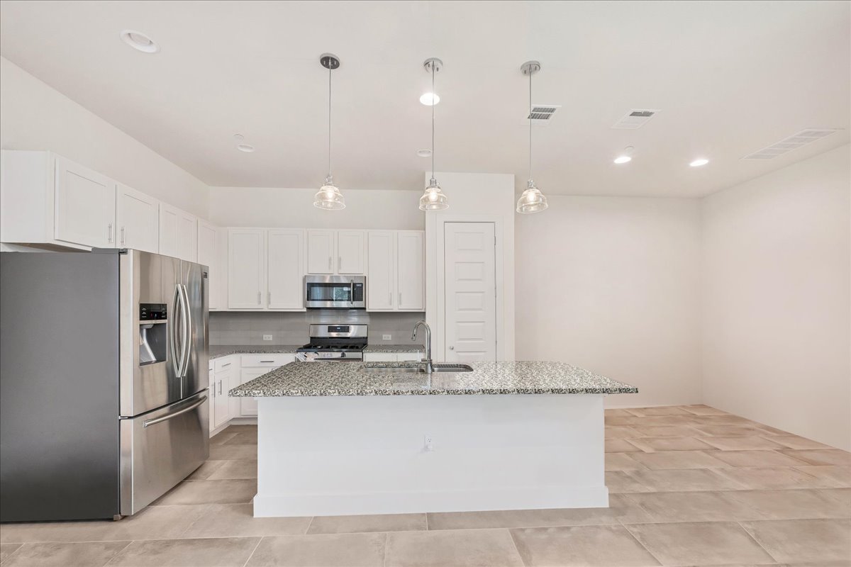 8922 Manchaca Road, Unit 906 Austin, TX 78748 - Photo 13 of 29 a large kitchen with kitchen island a refrigerator a stove a sink and a oven