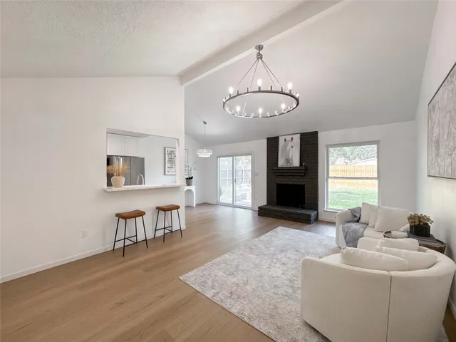a living room with furniture a chandelier and a fireplace