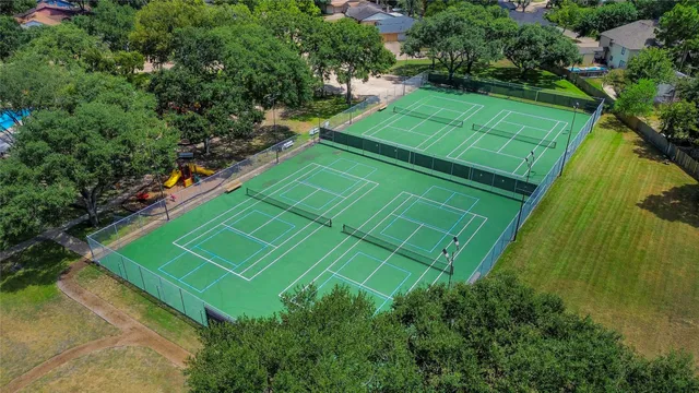 a green field with trees in the background