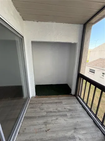 a view of an empty room with wooden floor and stairs