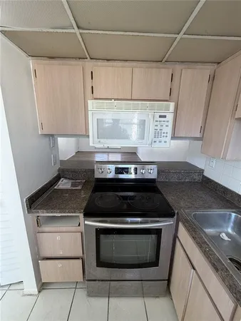 a kitchen with granite countertop a stove and a sink