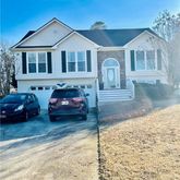 a front view of a house with cars parked