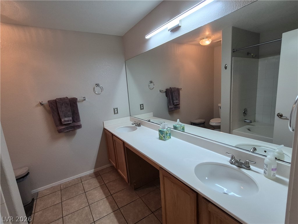 2053 Quarry Ridge Street, Unit 201 Las Vegas, NV 89117 - Photo 13 of 21 Double vanity with ample counter space and a large mirror defines this functional bathroom.