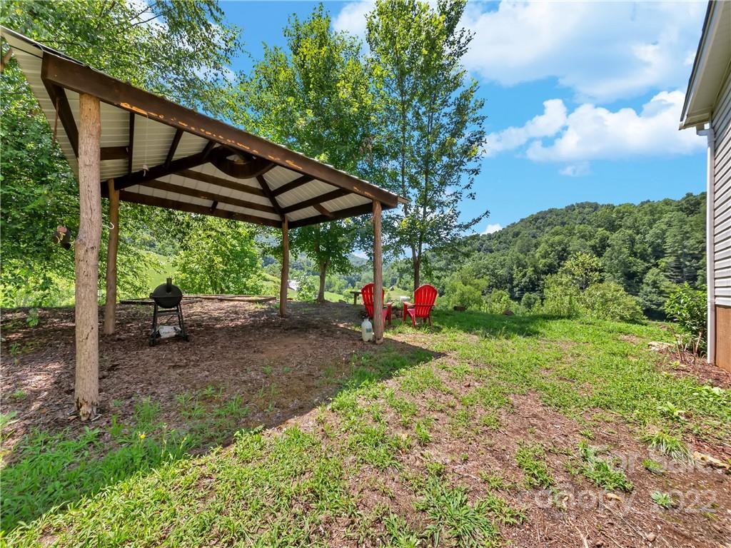 70 Sugar Cove Road Clyde, NC 28721 - Photo 18 of 21 a view of a backyard with table and chairs under an umbrella