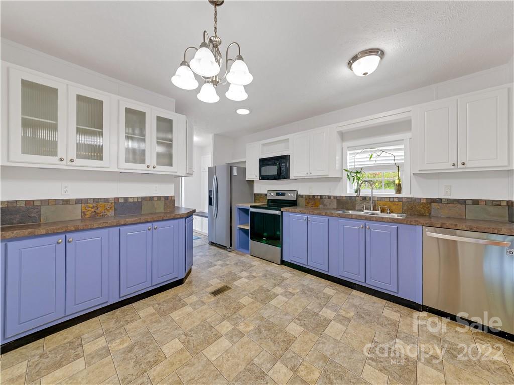 70 Sugar Cove Road Clyde, NC 28721 - Photo 6 of 21 a large kitchen with stainless steel appliances granite countertop a stove and cabinets