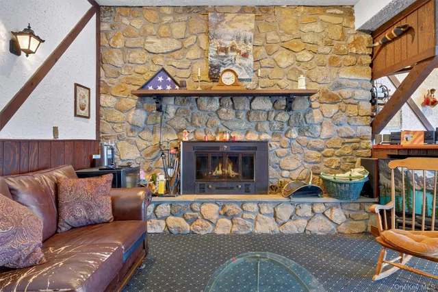 a living room with furniture a flat screen tv and a floor to ceiling window
