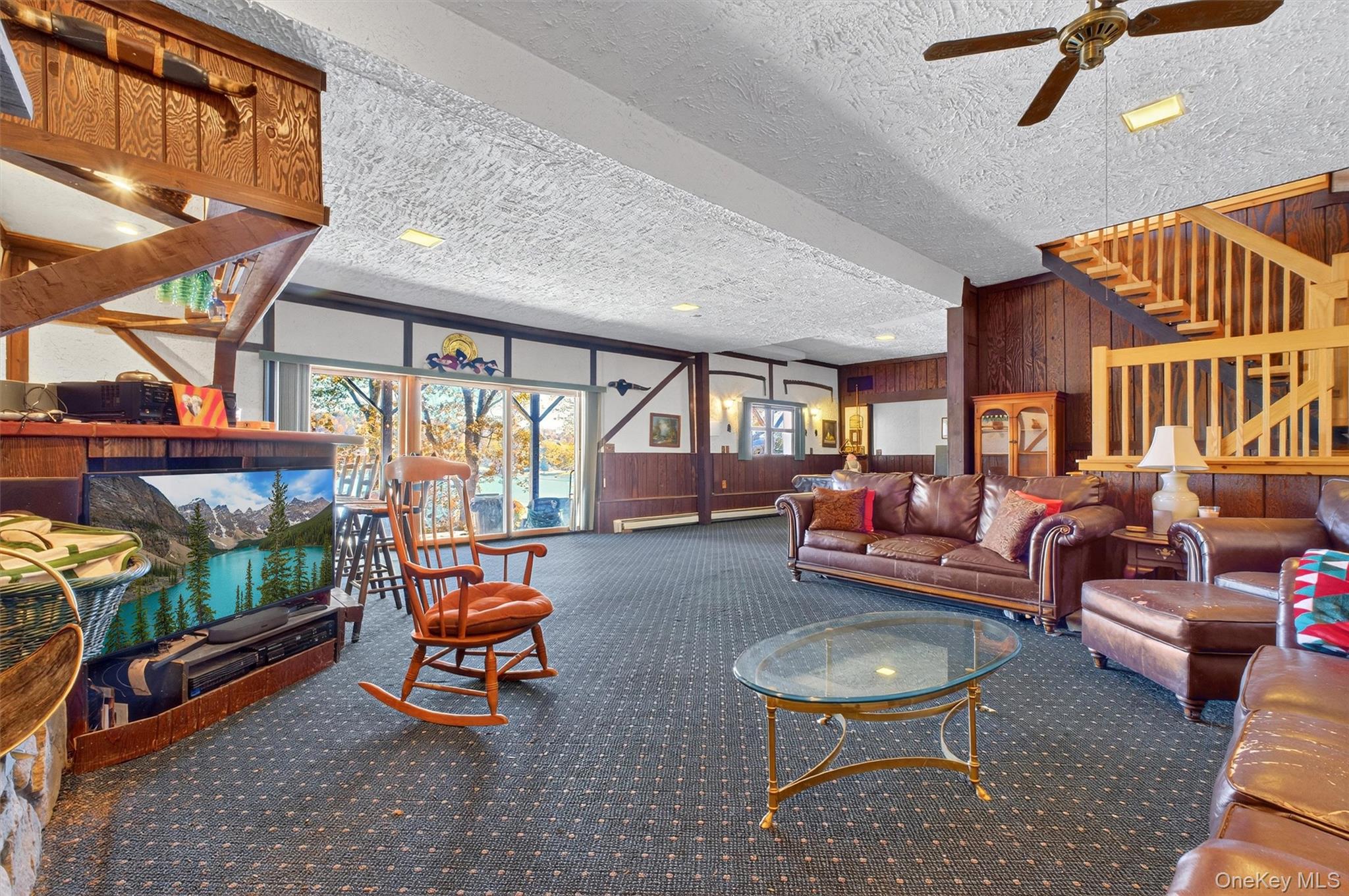 10 Byram Road Carmel, NY 10512 - Photo 27 of 49 a living room with furniture a flat screen tv and a floor to ceiling window