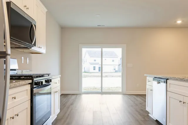a kitchen with granite countertop a stove and a microwave