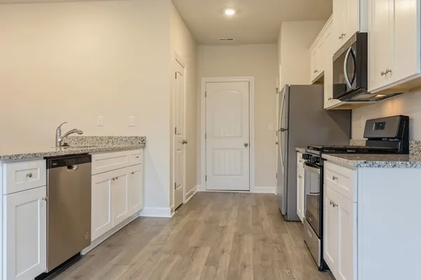 a kitchen with stainless steel appliances granite countertop a refrigerator and a stove top oven