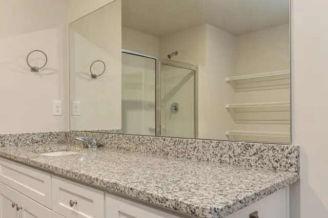 a bathroom with a granite countertop sink and a mirror