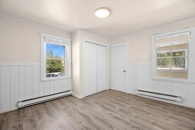 an empty room with wooden floor and windows