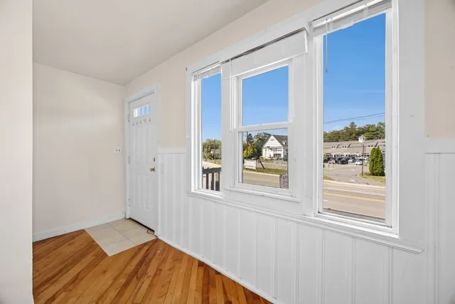 a view of a bedroom with wooden floor and windows